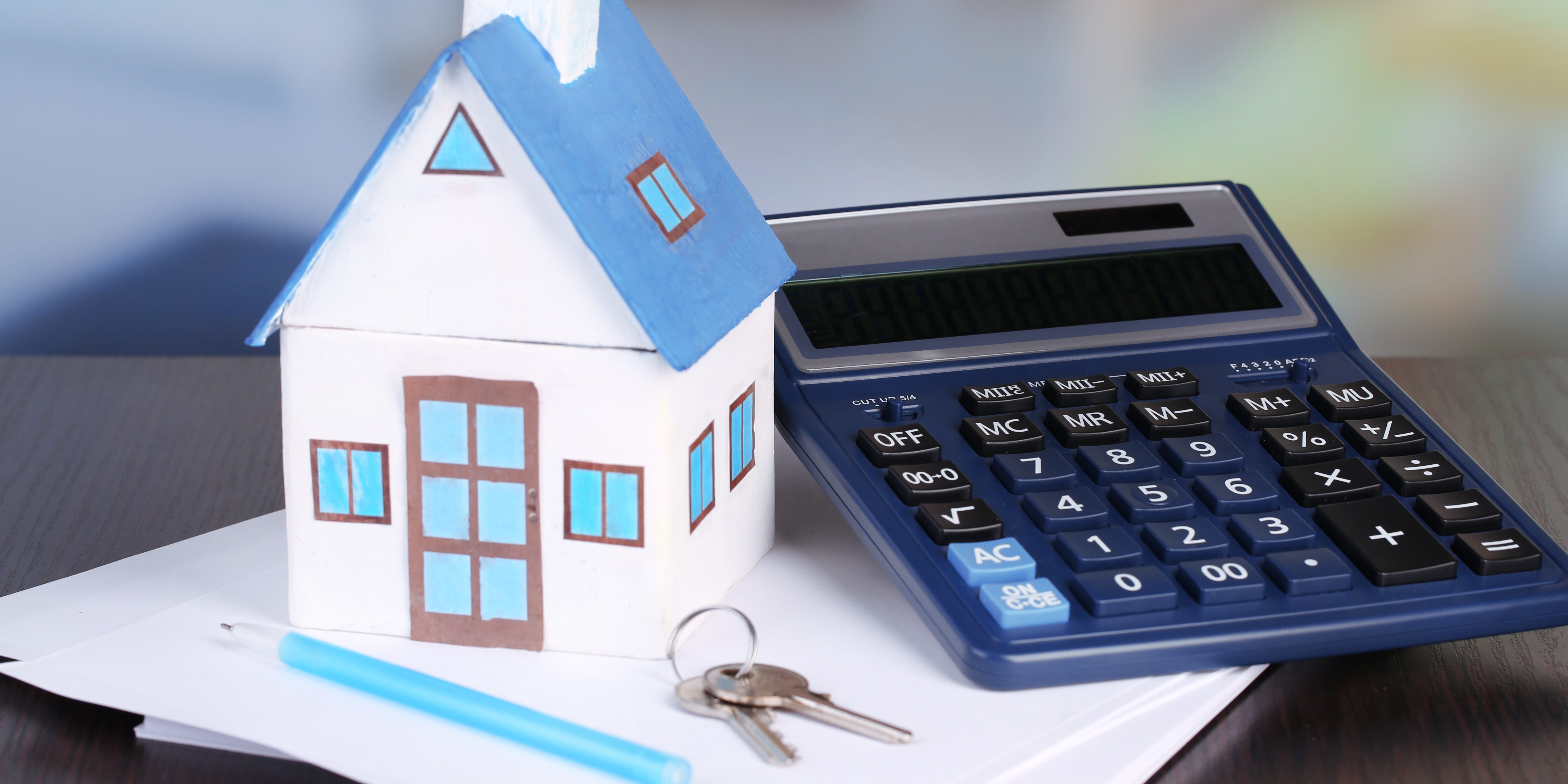 Toy house and calculator on table close-up