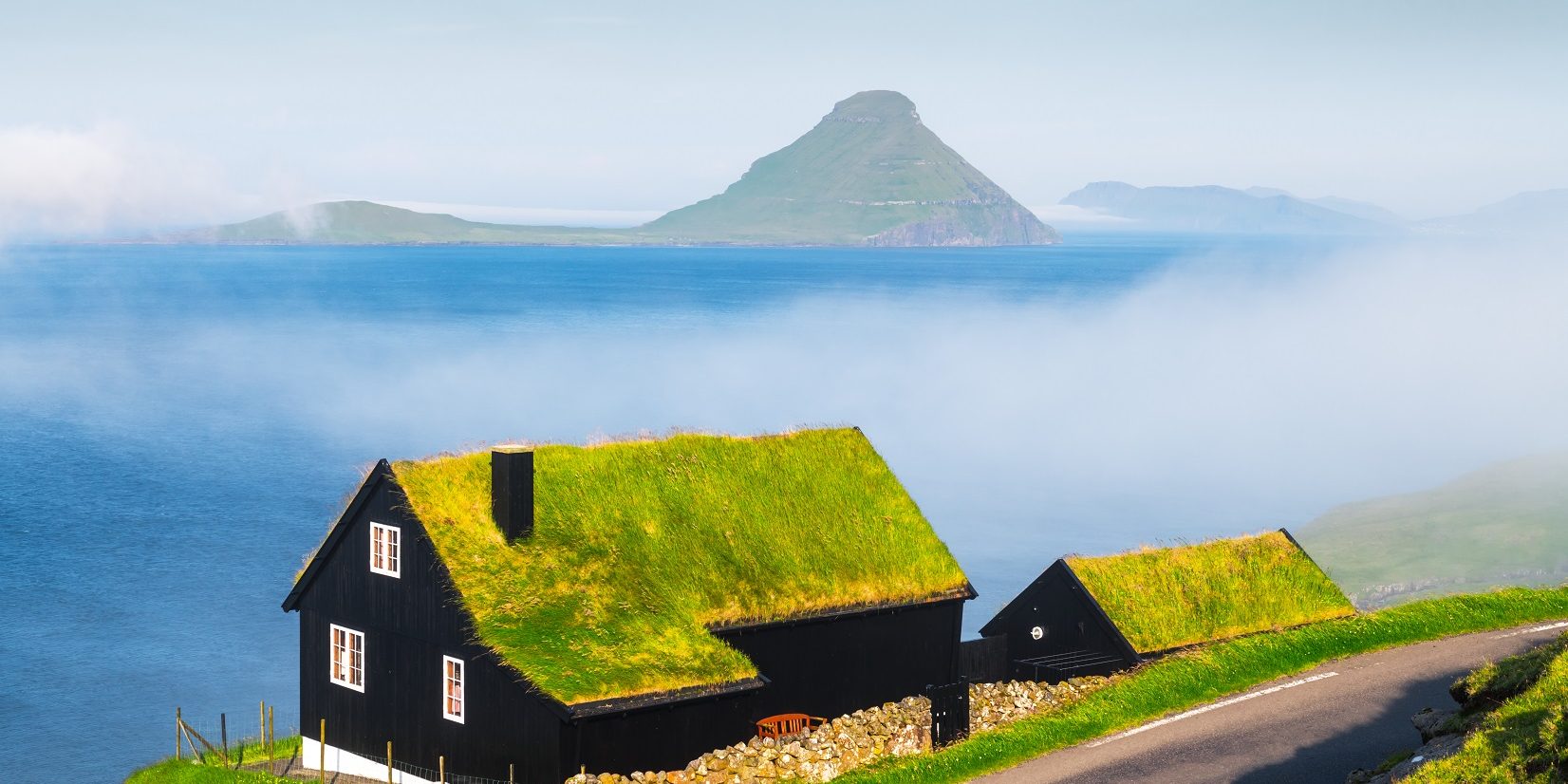 Foggy morning view of a house with typical grass roof