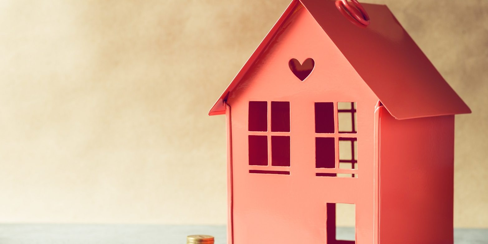 Metal red model of a house and stairs of golden coins. The concept rental or buying the estate.