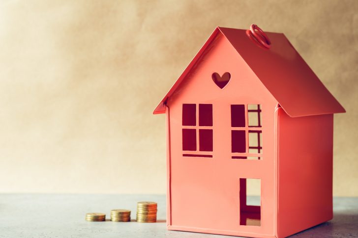 Metal red model of a house and stairs of golden coins. The concept rental or buying the estate.