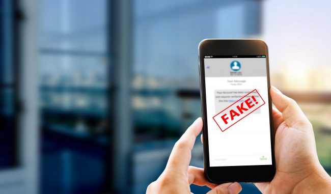 Fake Text message SMS scam or phishing concept. Man hands using