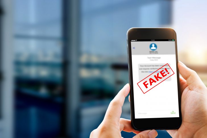 Fake Text message SMS scam or phishing concept. Man hands using