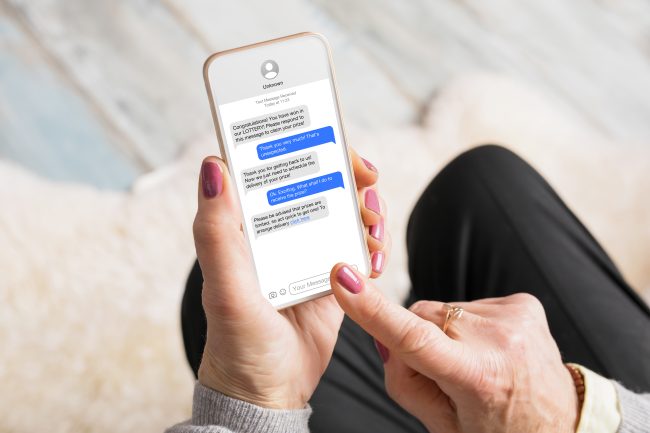 Old woman receiving scam messages on her mobile phone