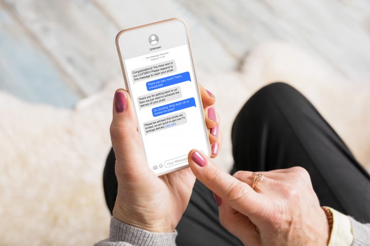 Old woman receiving scam messages on her mobile phone